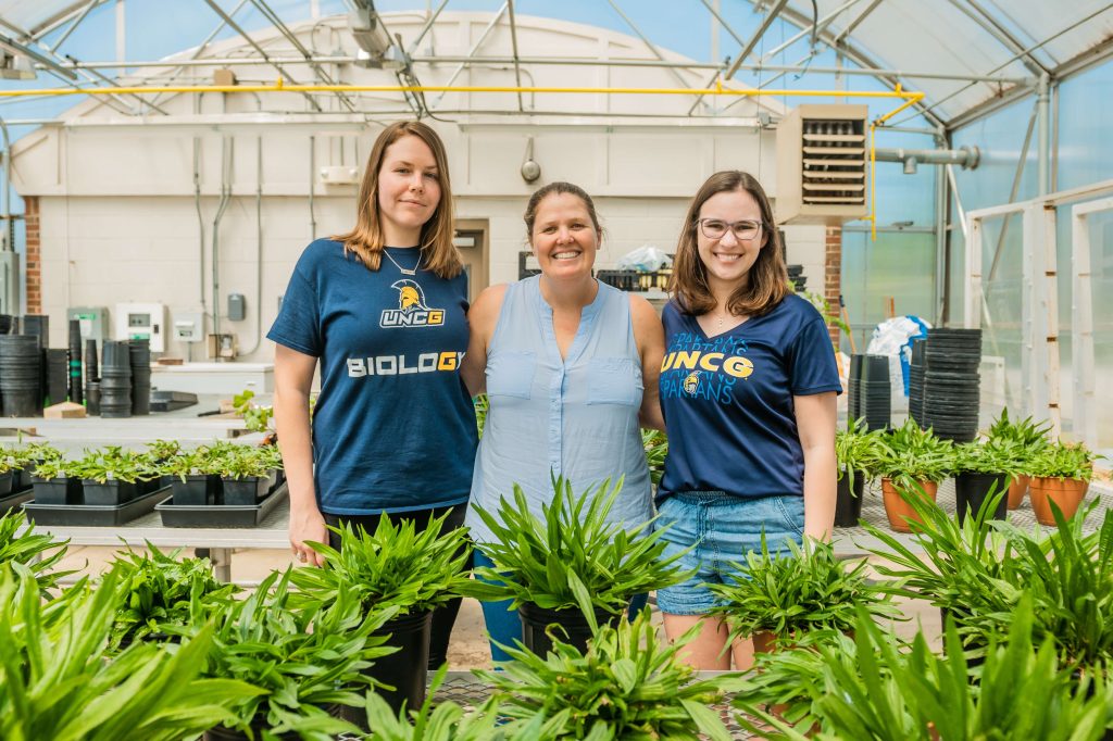 Dr. Sally Koerner and two students in the Northridge Greenhouse