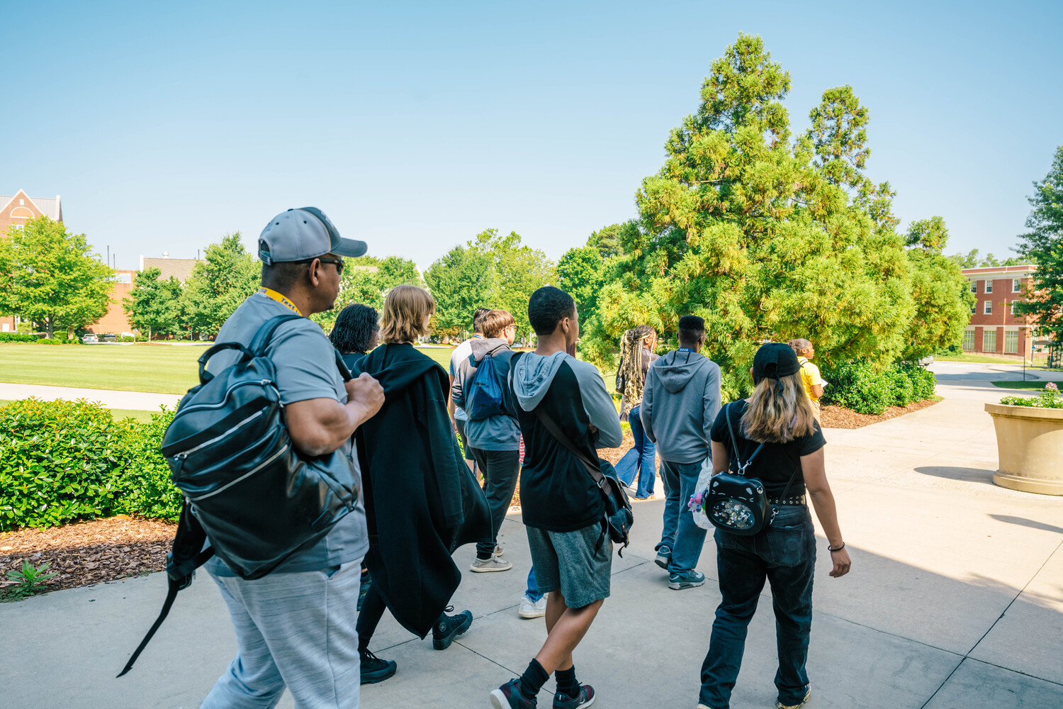 a group of students walks past us on a sunny day.